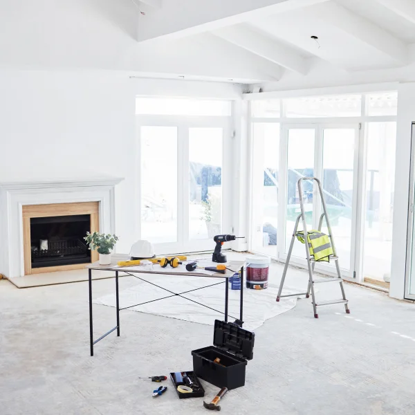 Intérieur d'une pièce comprenant une table, une chaise et une échelle, offrant une atmosphère simple et pratique