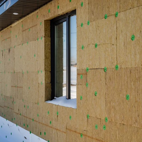 Un bâtiment avec du ruban vert sur les fenêtres, illustrant des travaux d'isolation thermique.