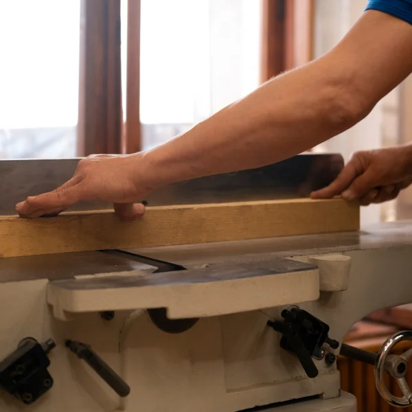Une personne utilise une scie sur table pour couper du bois pour des portes sur mesure.